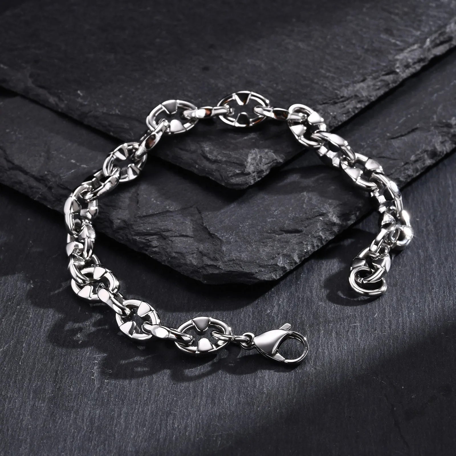 Stainless steel thick geometric chain bracelet on a wrist, showing handmade links and steel colour finish.