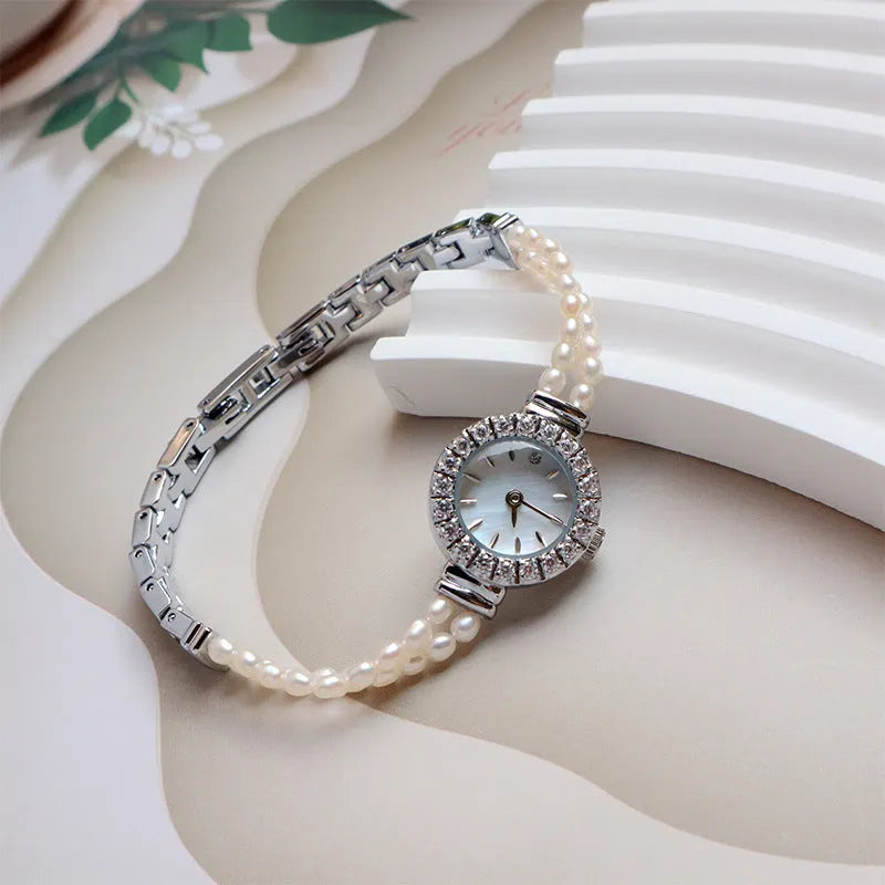 Women's light gold bracelet watch with freshwater pearls, round mineral glass dial, and stainless steel folding buckle