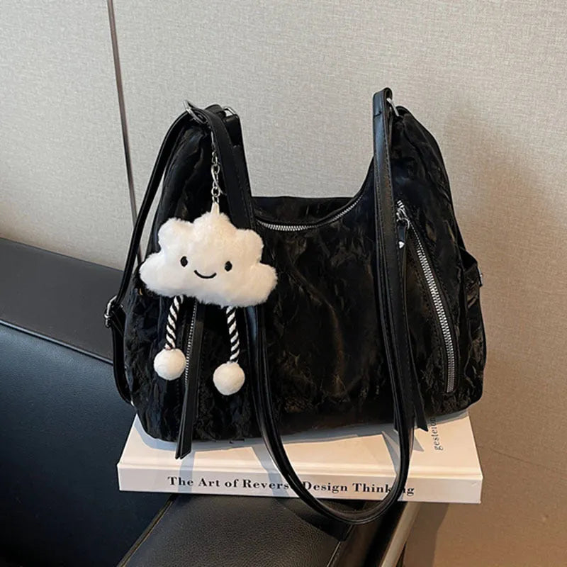 Soft black women's fashion backpack made from wear-resistant PU material, shown with a matching pendant.