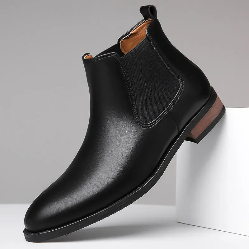 Men's black pointed toe Chelsea boots with a round toe shape and rubber sole.