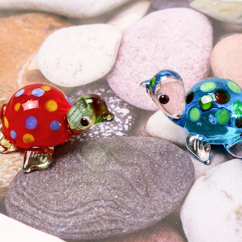 Geometric glass turtle ornament in a modern style with a coloured shell, displayed on a desktop.