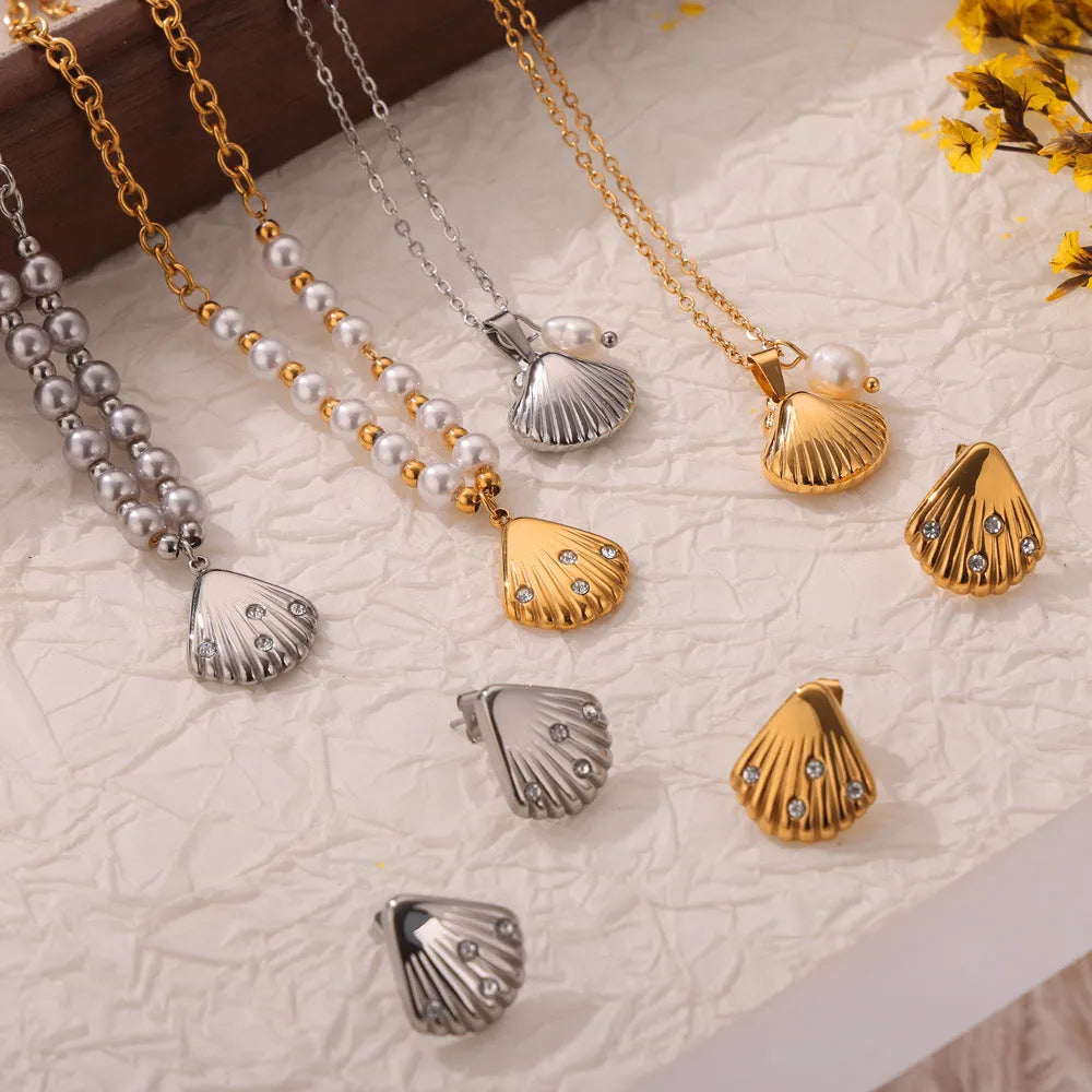 Gold tone women's necklace with shell pendant and freshwater pearl bead on O-chain.
