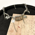 Dark multi-layer necklace with hemp flower chain links and a cross pendant on an adjustable 41-50cm chain.