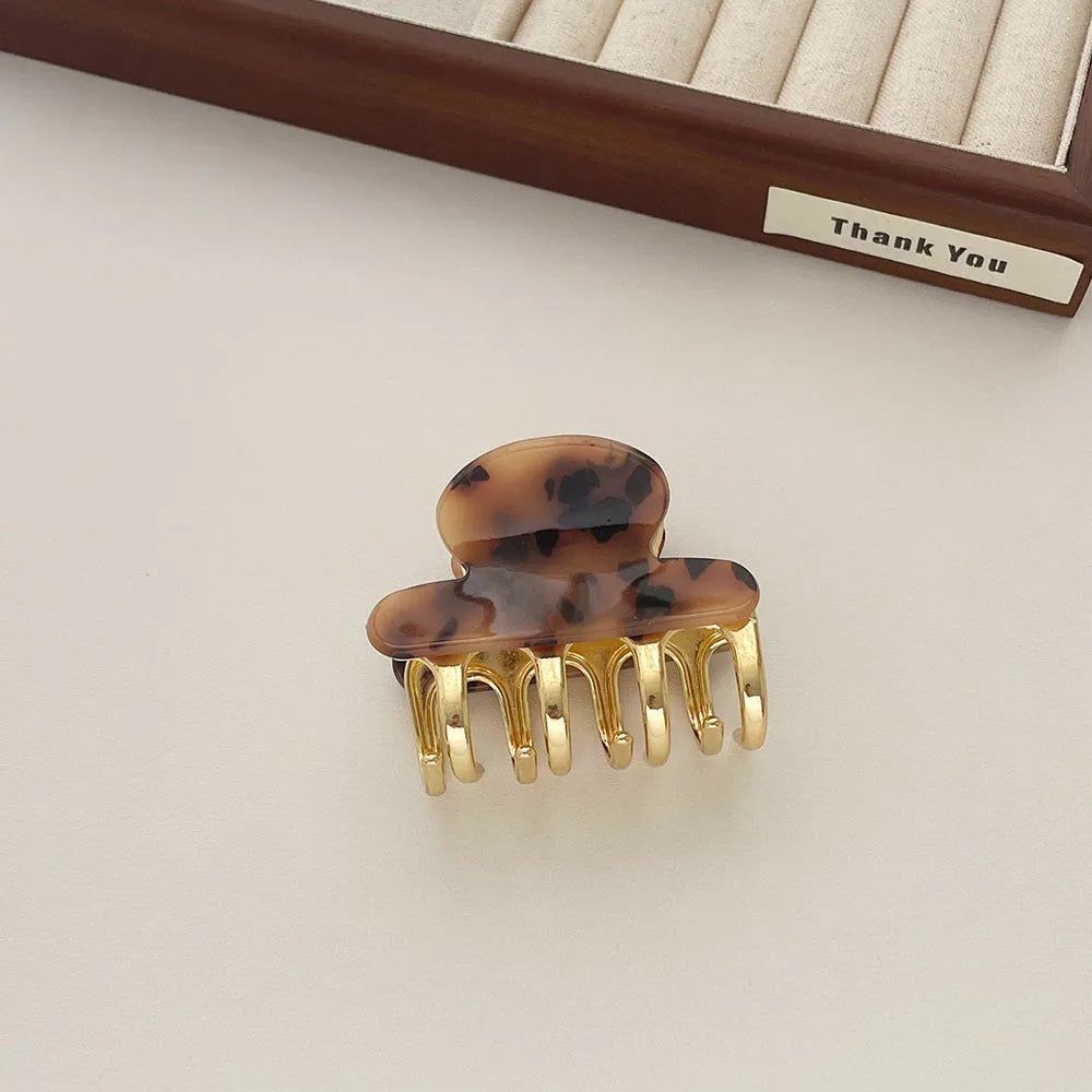 A medium-size retro-style hair barrette with a metal grip, in an alloy acrylic construction.