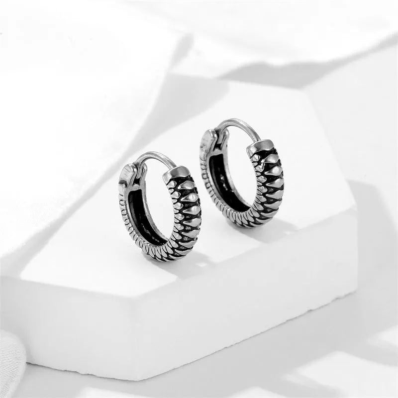 Silver geometric retro twist earrings with stripes made from titanium steel on a white background.
