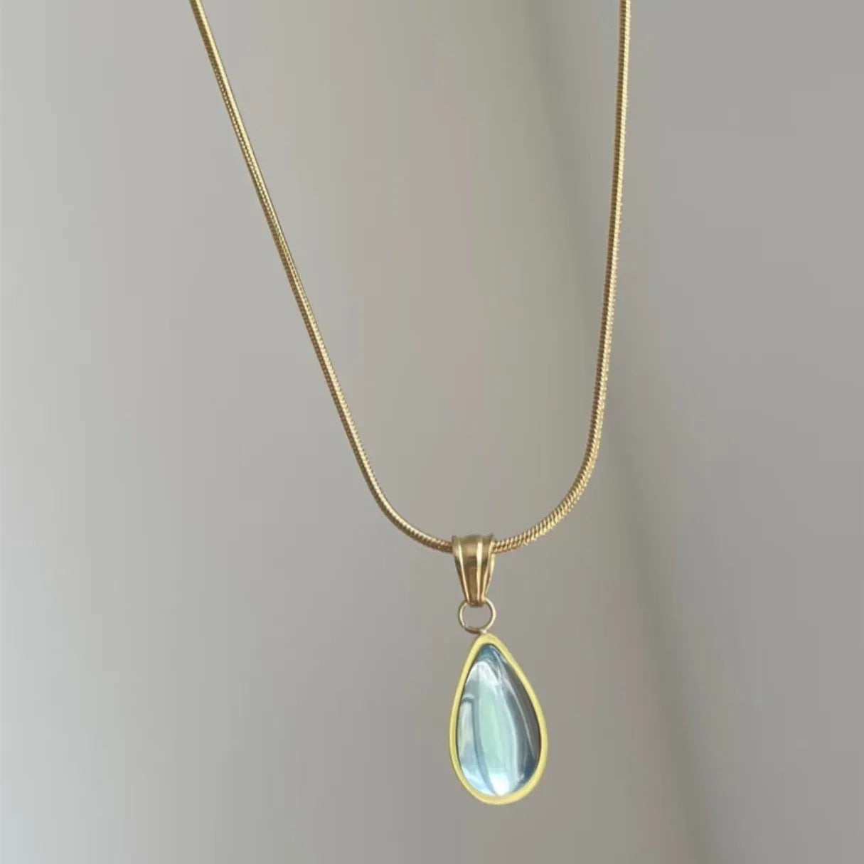 Retro water drop necklace with blue gem inlay on a titanium steel snake bone chain.