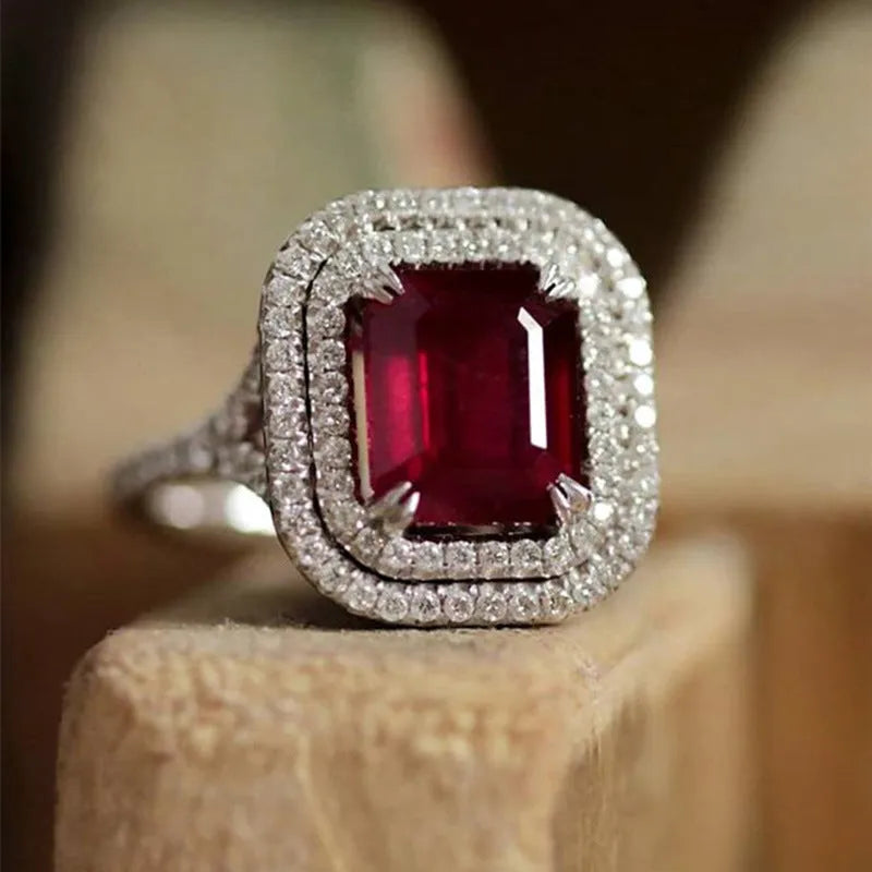 Women's square ring with copper band and red rhinestones on a geometric face.