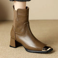 Brown cowhide leather Martin boots with side zip and high heel on wooden floor