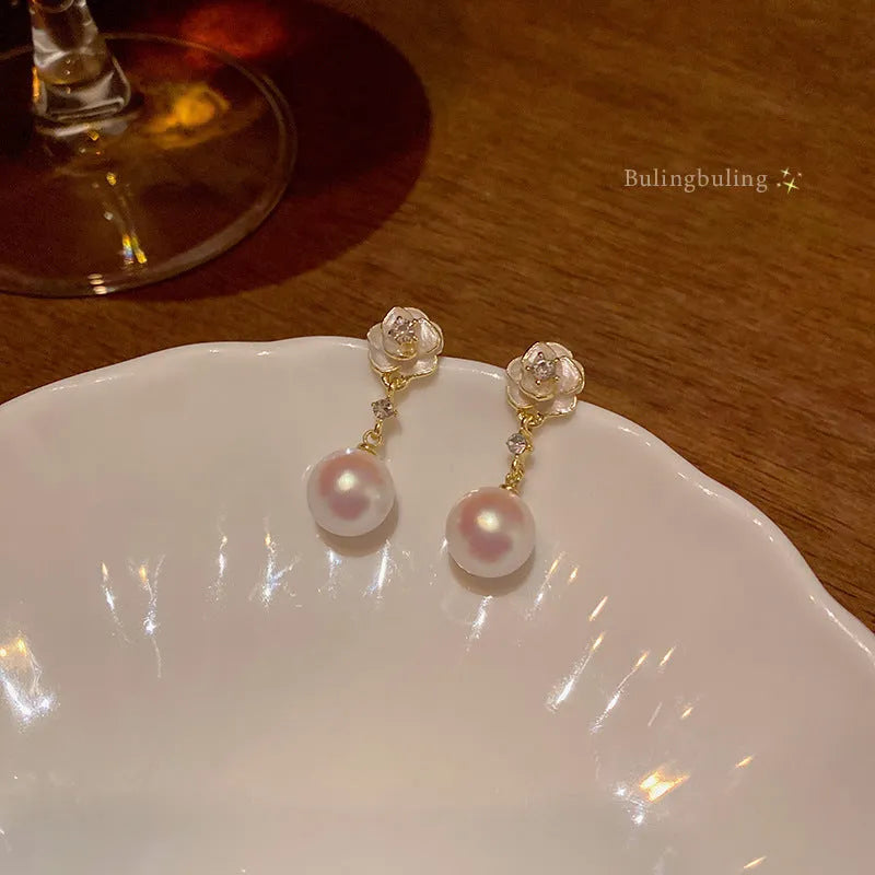 Camellia flower shaped stud earrings in alloy metal with floral design details