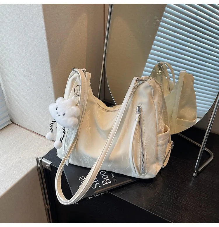 Soft black women's fashion backpack made from wear-resistant PU material, shown with a matching pendant.