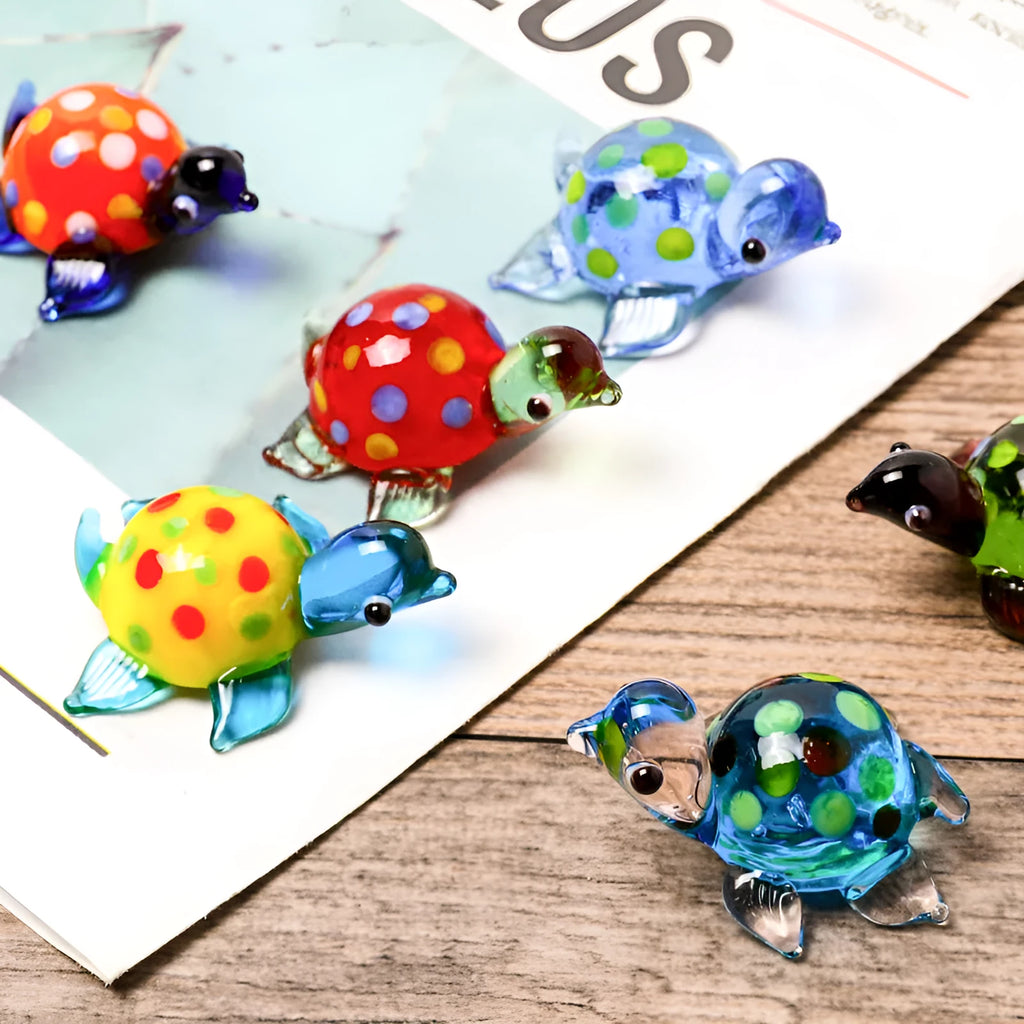Geometric glass turtle ornament in a modern style with a coloured shell, displayed on a desktop.