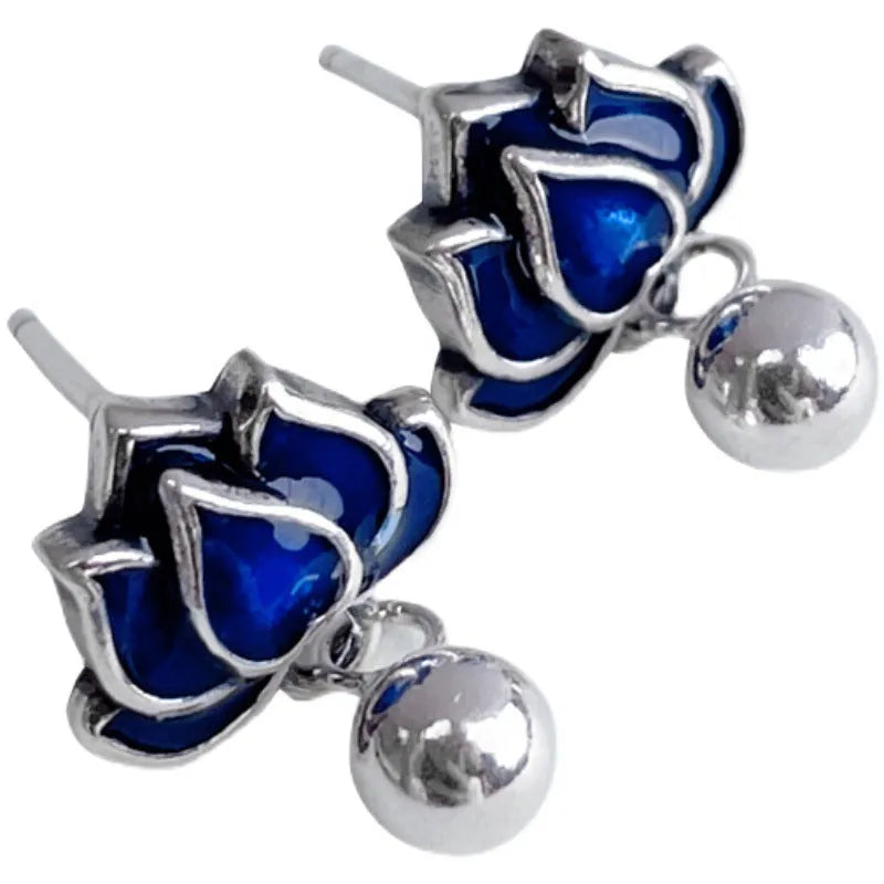Blue lotus flower ear studs with seedpod tassel detail on an alloy backing.