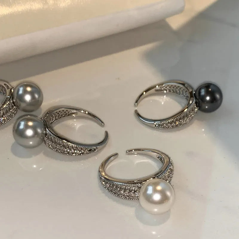Geometric open copper ring with black pearl finish on a model's finger, showing adjustable design.