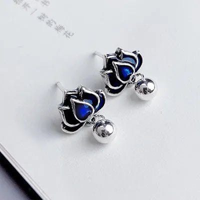 Blue lotus flower ear studs with seedpod tassel detail on an alloy backing.