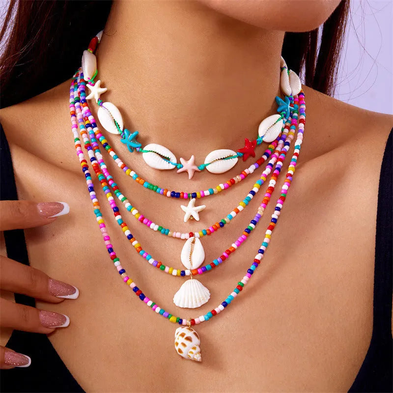 Women's multi-layer necklace set with blue shell pendants and beads, showing five coordinated designs