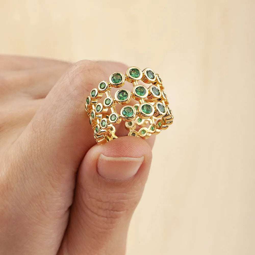 Copper ring with 18K gold plating showing three-layer exaggerated design and green zirconia stones