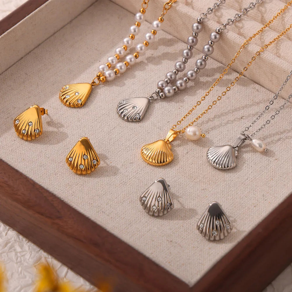 Gold tone women's necklace with shell pendant and freshwater pearl bead on O-chain.