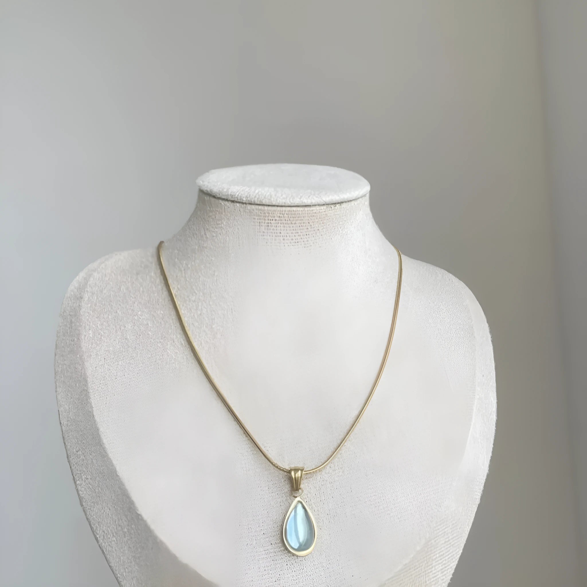 Retro water drop necklace with blue gem inlay on a titanium steel snake bone chain.