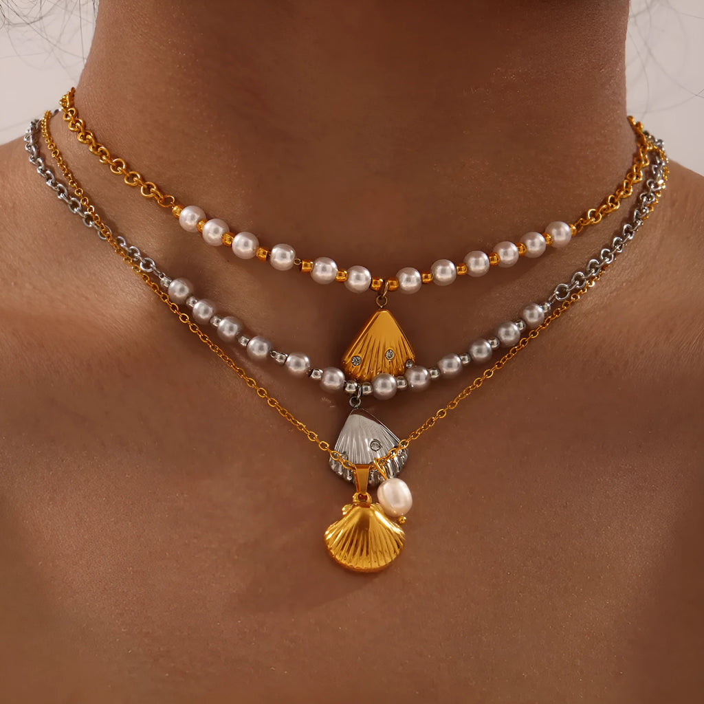 Gold tone women's necklace with shell pendant and freshwater pearl bead on O-chain.
