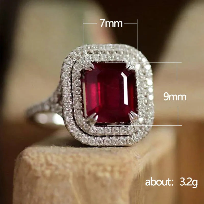 Women's square ring with copper band and red rhinestones on a geometric face.