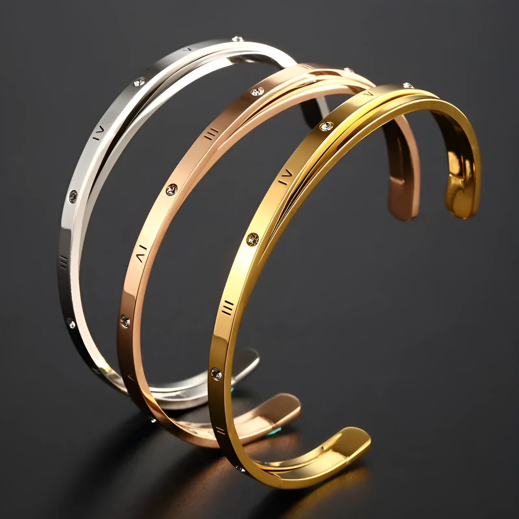 Open-ended stainless steel ladies bracelet with a love symbol and zircon detail, shown in rose gold finish.