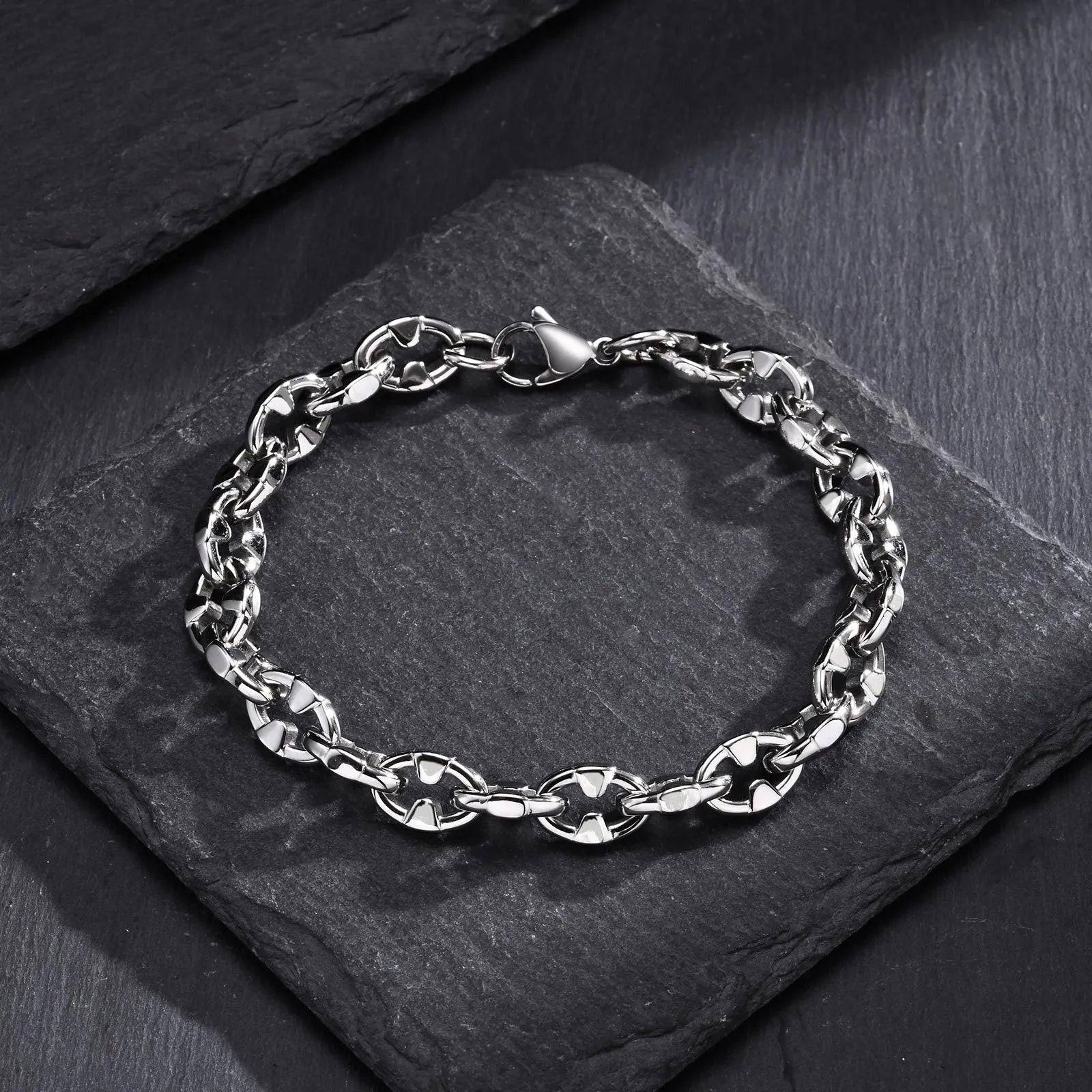 Stainless steel thick geometric chain bracelet on a wrist, showing handmade links and steel colour finish.