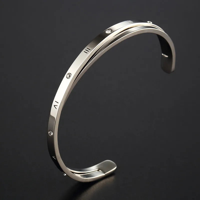 Open-ended stainless steel ladies bracelet with a love symbol and zircon detail, shown in rose gold finish.