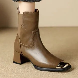 Brown cowhide leather Martin boots with side zip and high heel on wooden floor