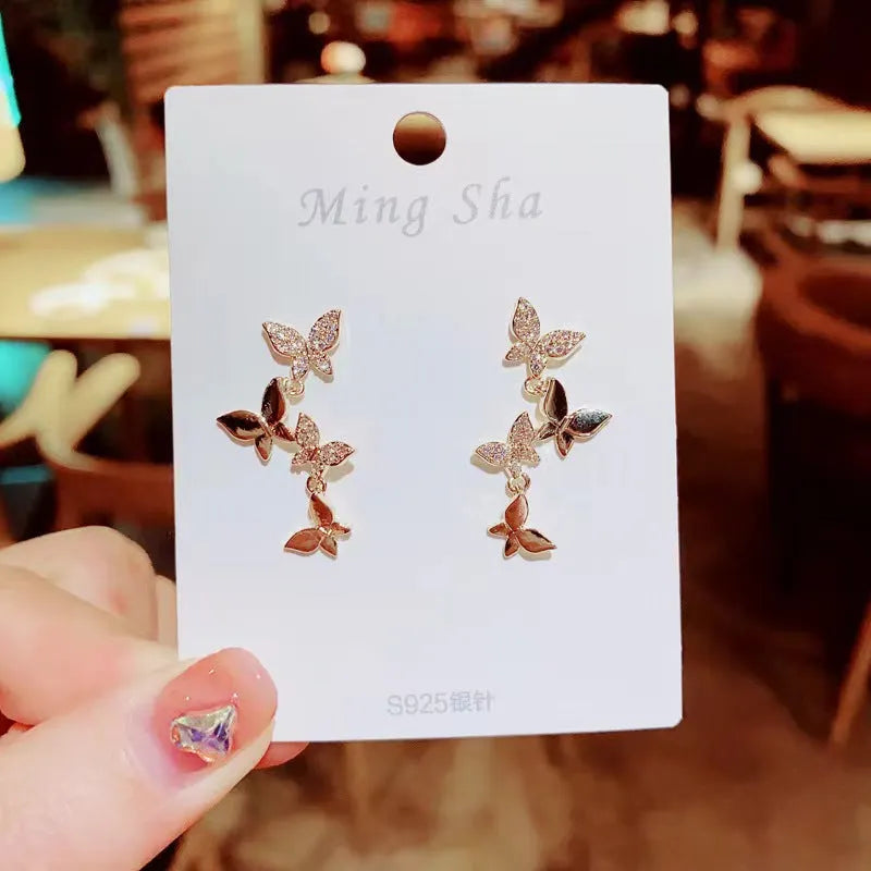 Gold coloured copper earrings with four butterfly design elements for women