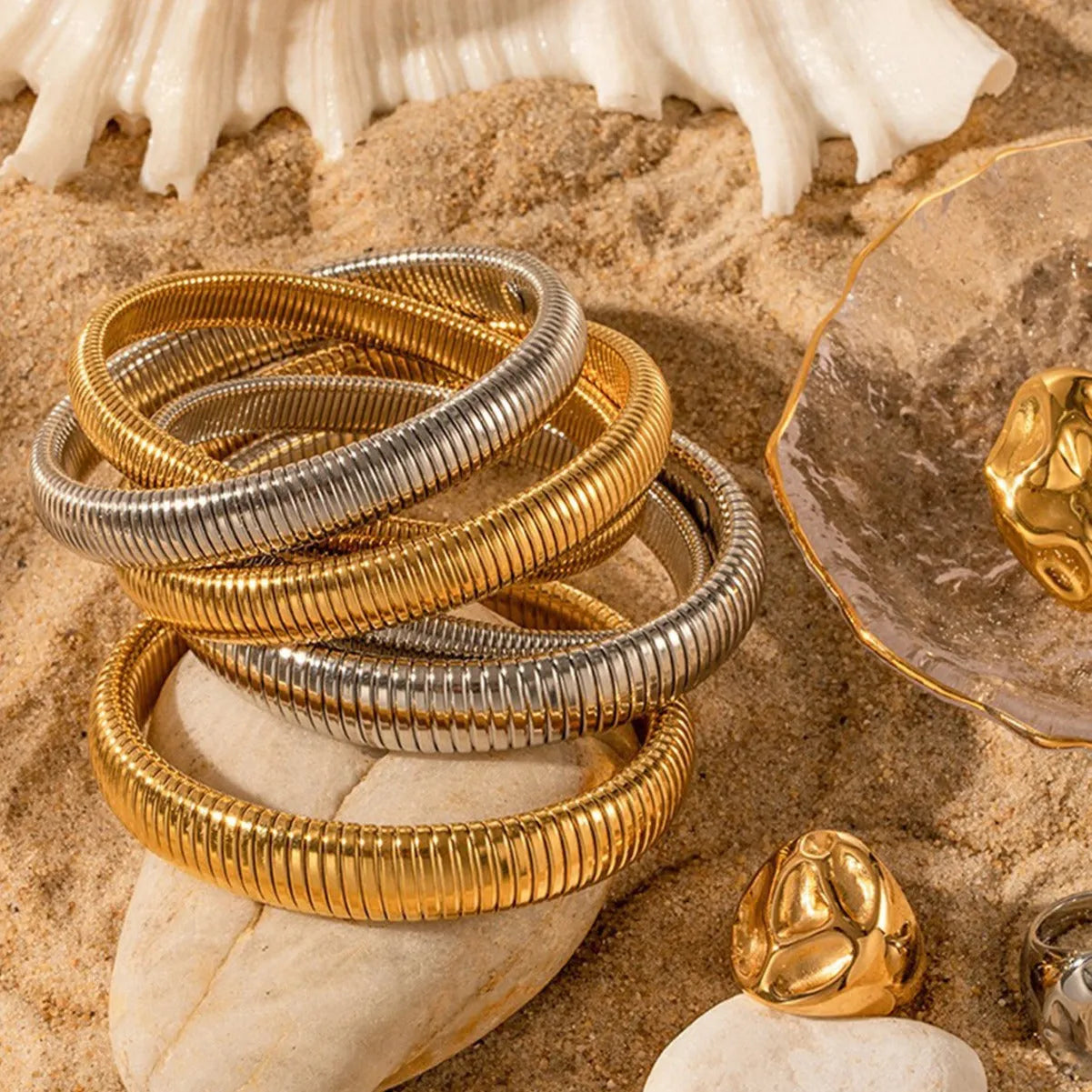 Women's titanium steel bracelet with elastic rings and vertical stripe pattern in gold or silver.