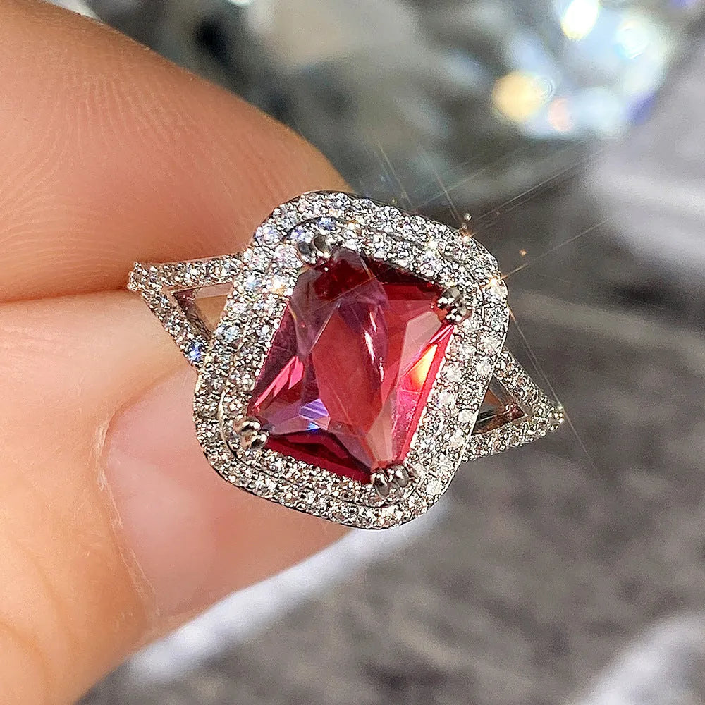 Women's square ring with copper band and red rhinestones on a geometric face.