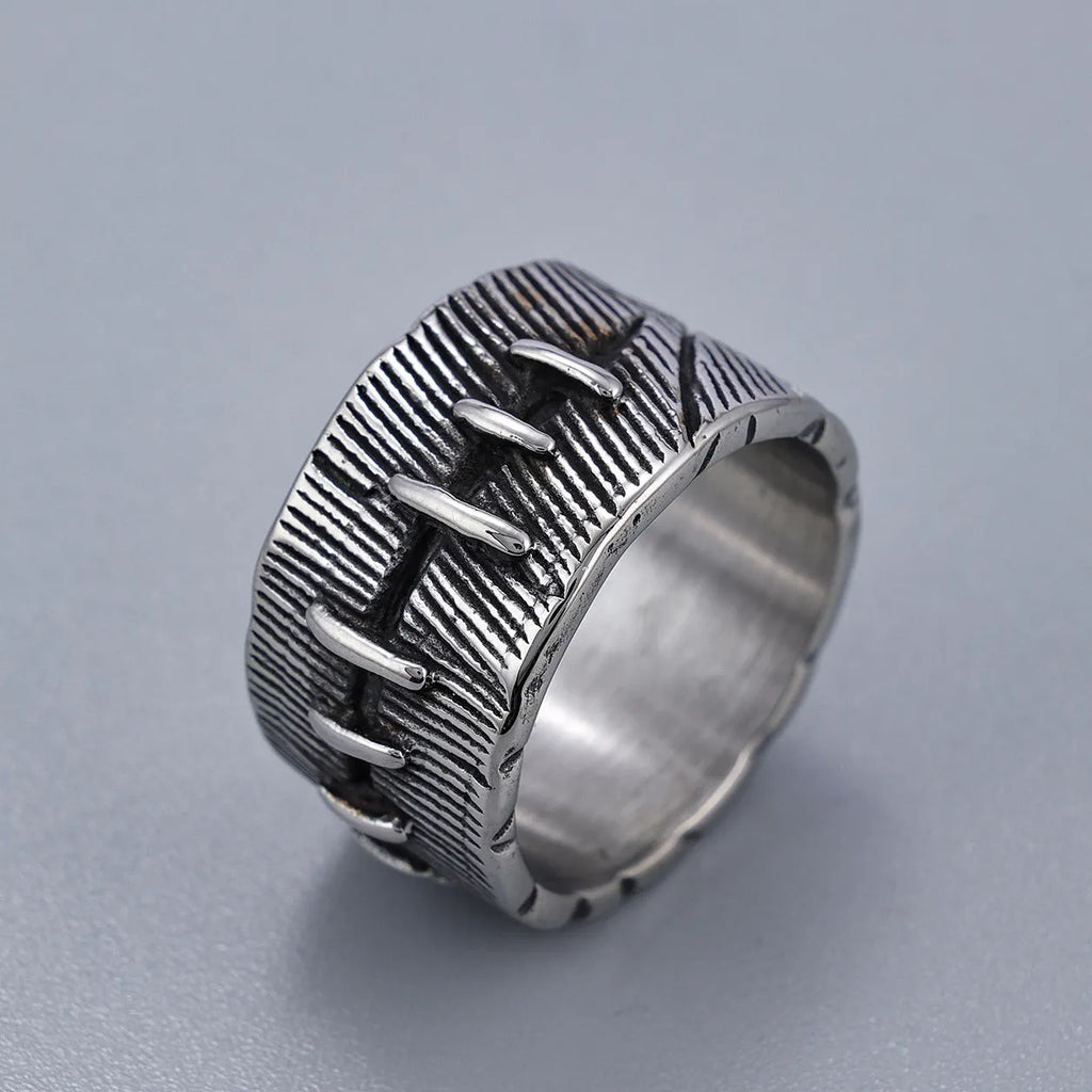 Geometric dark punk titanium steel double ring in retro colour, showing stitched design on a hand.