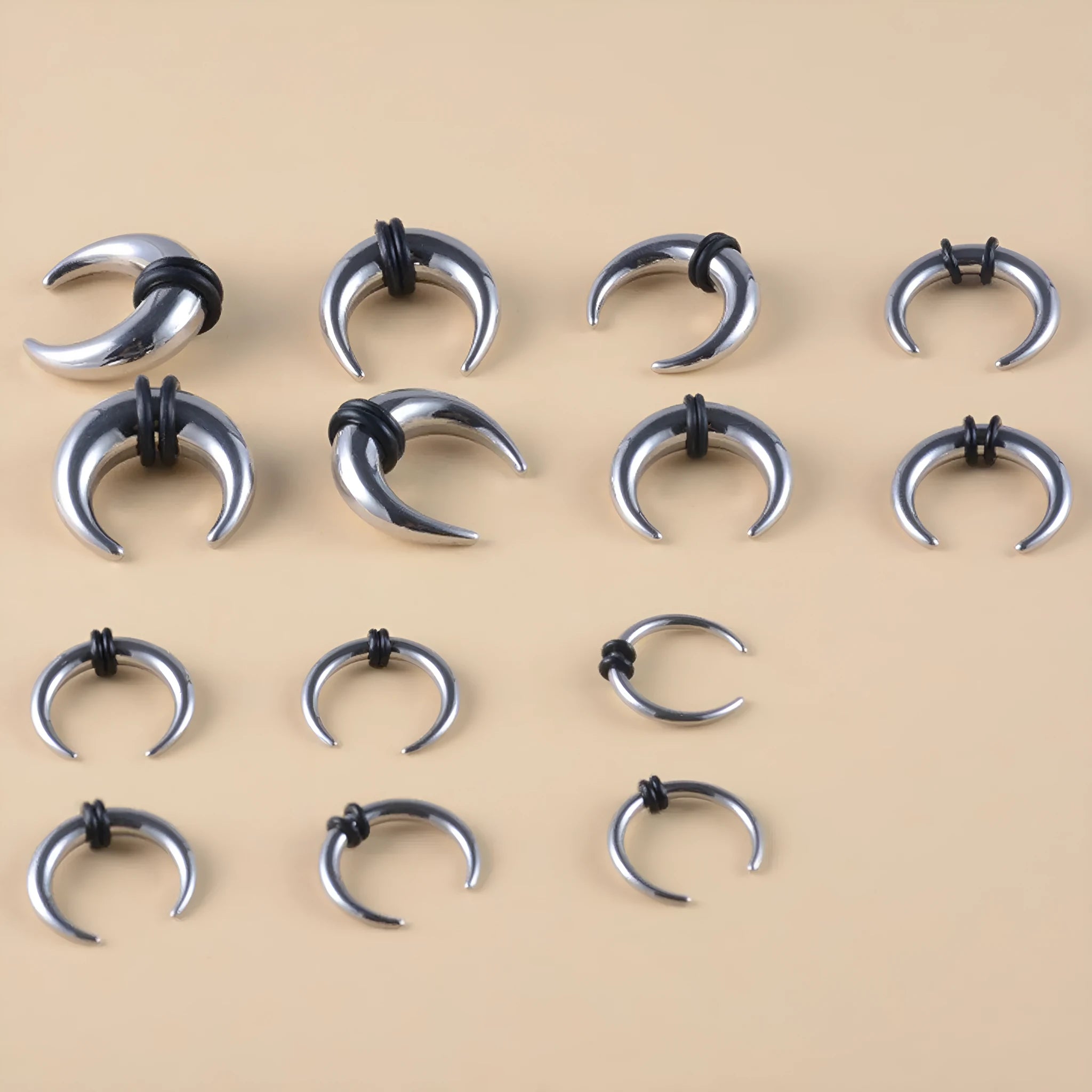 316L steel C-shaped nose ring in black and steel colour on a plain background, showing geometric shape.