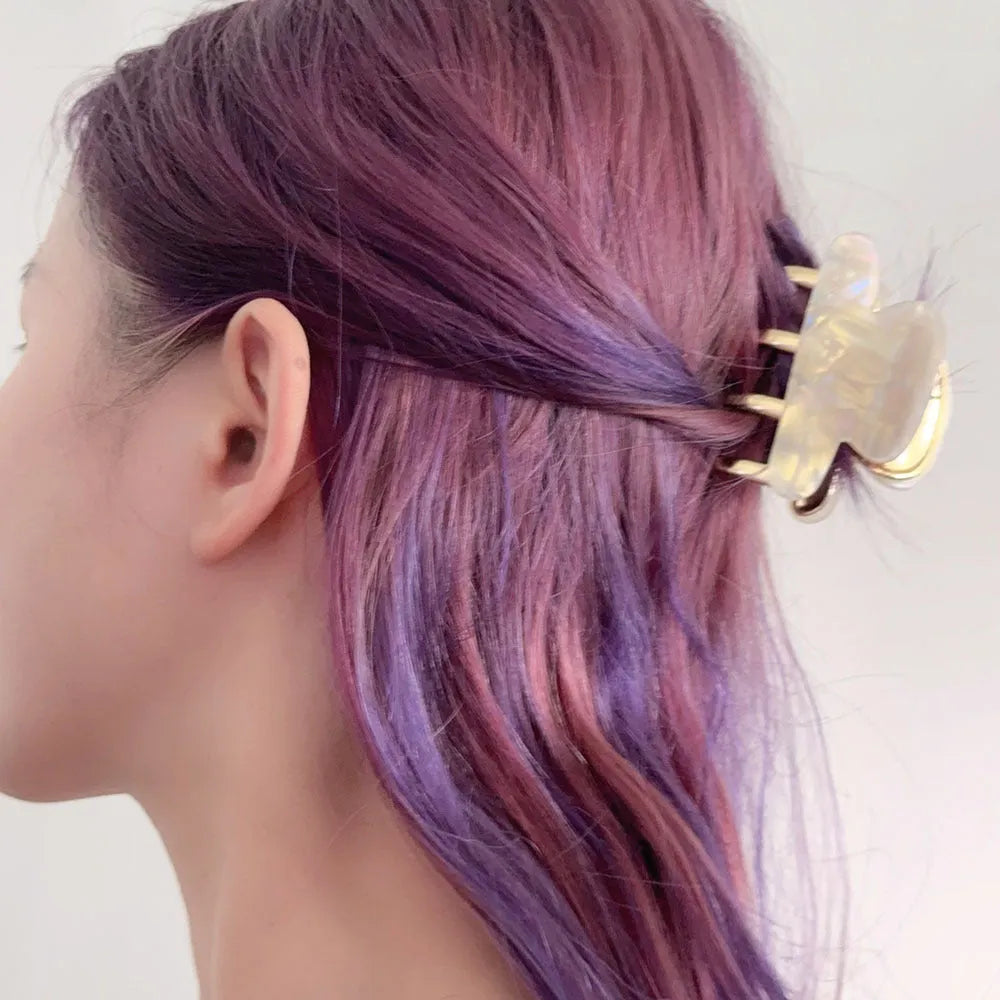 A medium-size retro-style hair barrette with a metal grip, in an alloy acrylic construction.