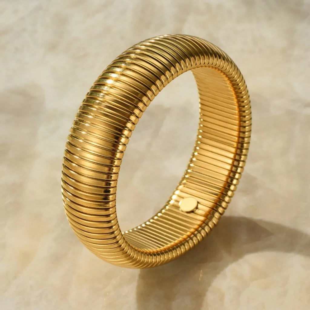 Women's titanium steel bracelet with elastic rings and vertical stripe pattern in gold or silver.
