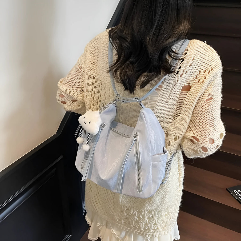 Soft black women's fashion backpack made from wear-resistant PU material, shown with a matching pendant.