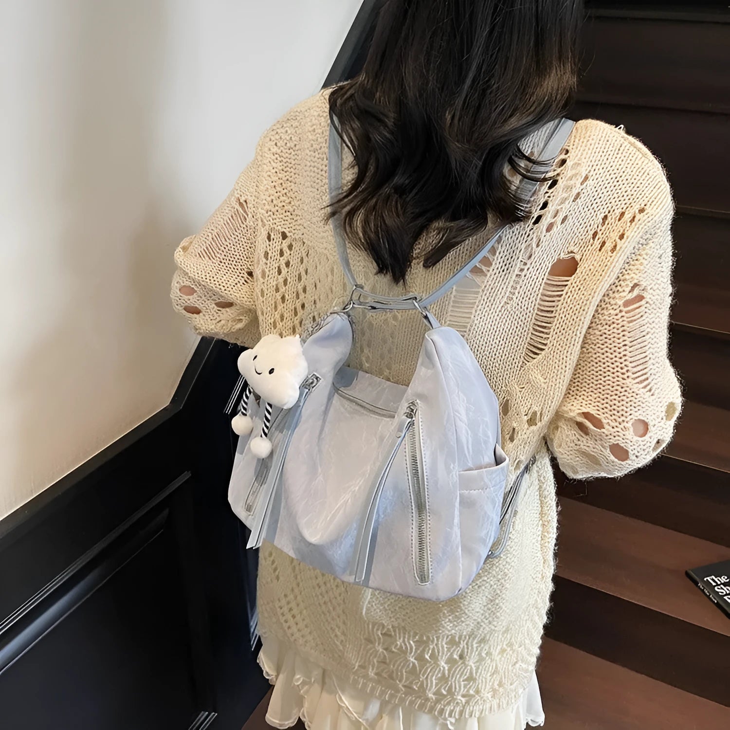 Soft black women's fashion backpack made from wear-resistant PU material, shown with a matching pendant.