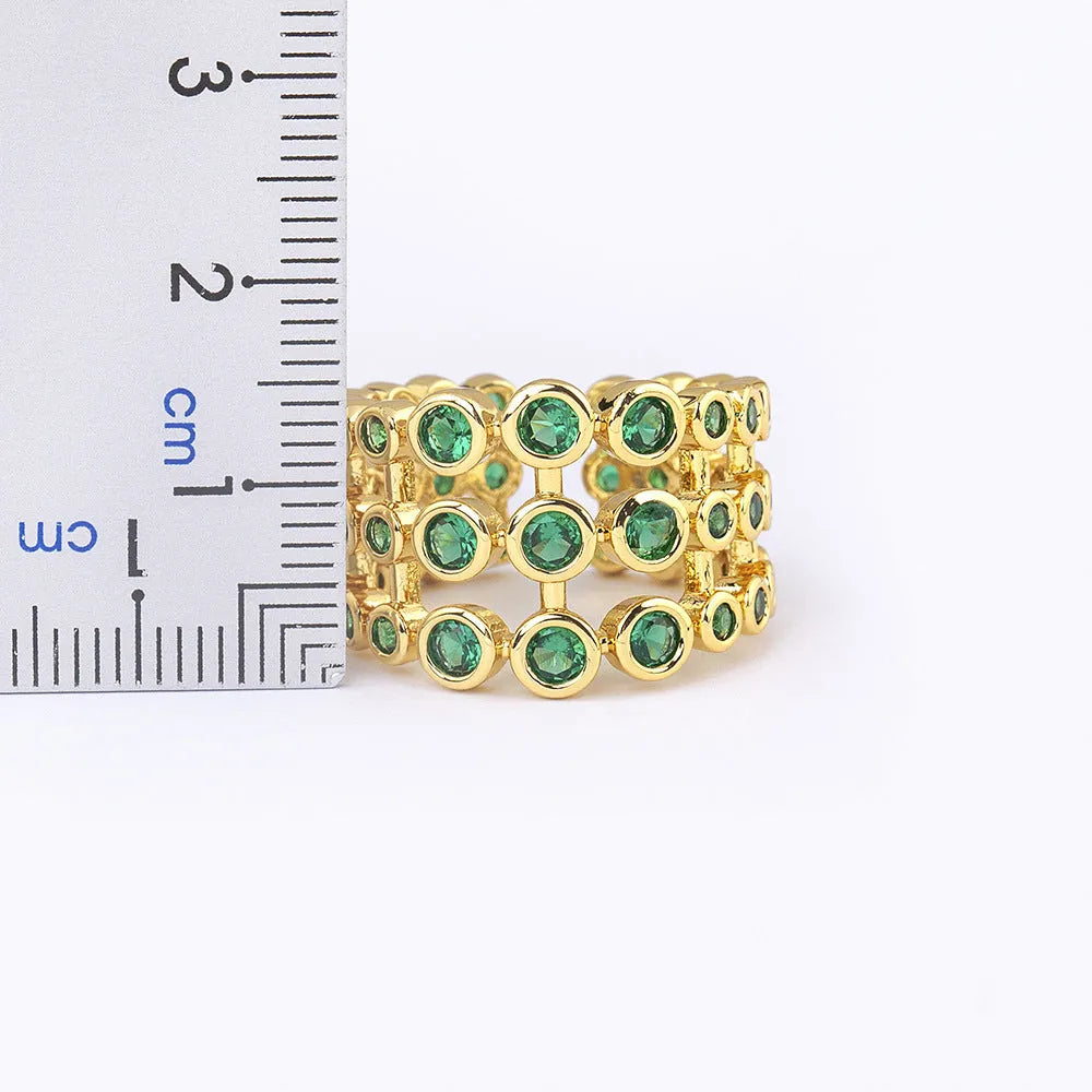 Copper ring with 18K gold plating showing three-layer exaggerated design and green zirconia stones