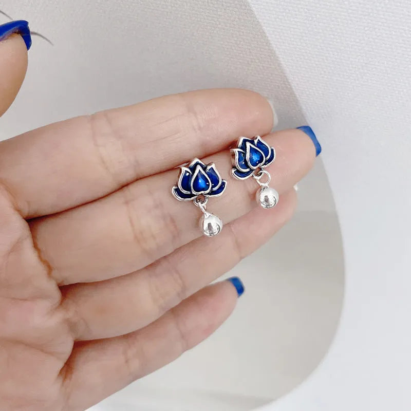 Blue lotus flower ear studs with seedpod tassel detail on an alloy backing.