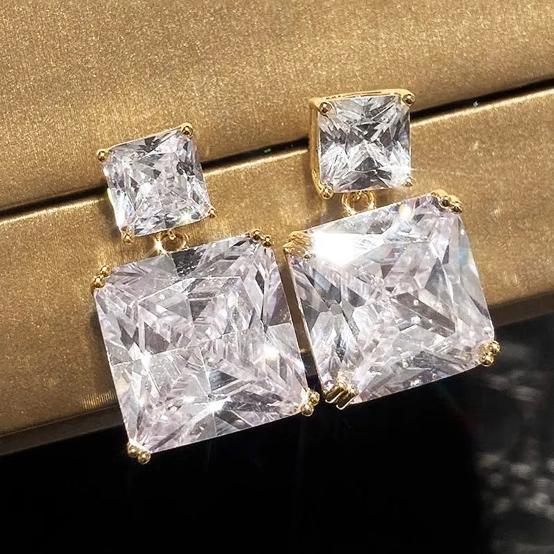 A pair of geometric square copper earrings with a quadrilateral design, shown in white gold and gold colour options.