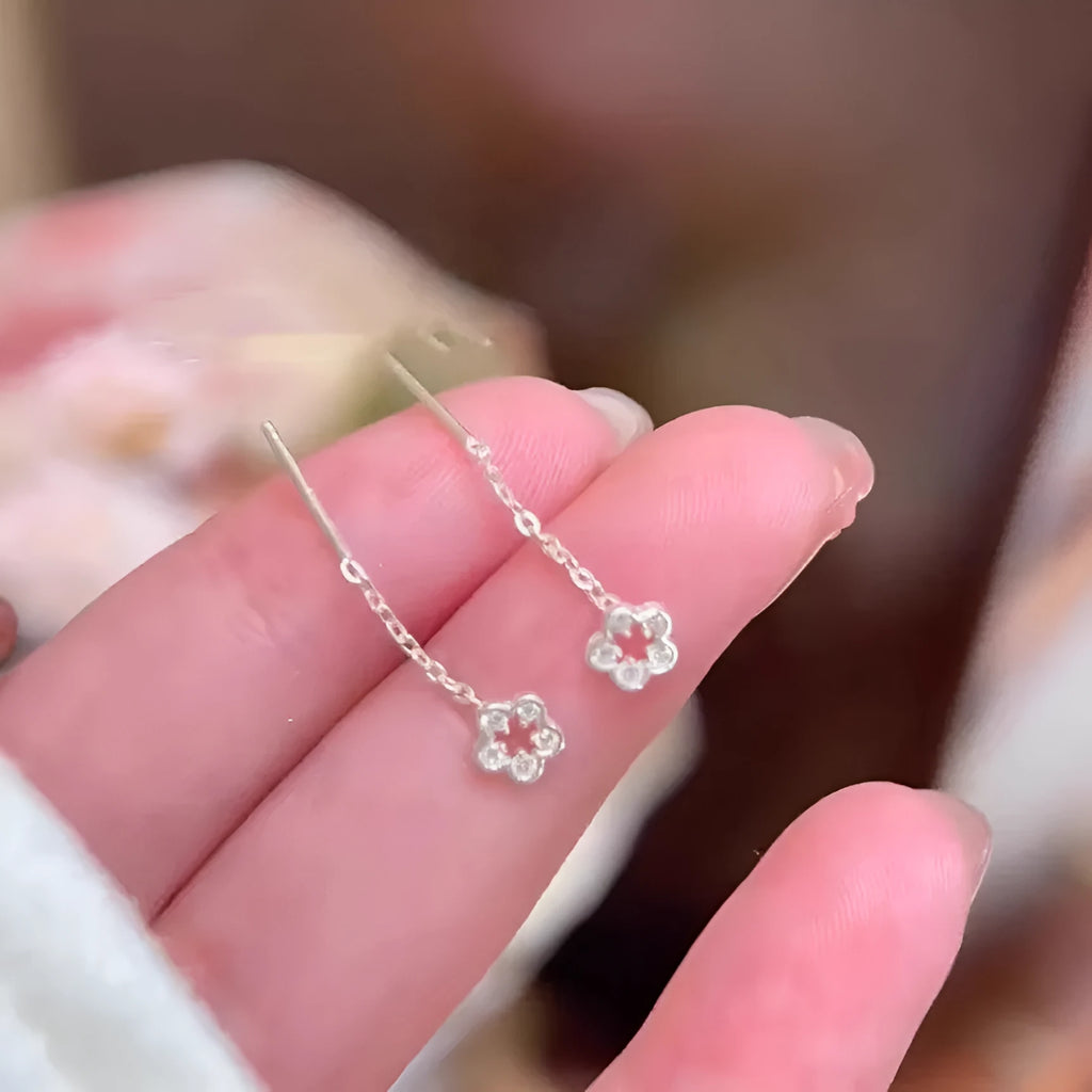 Pair of silver colour hollow flower stud earrings with detailed petal elements and needle posts
