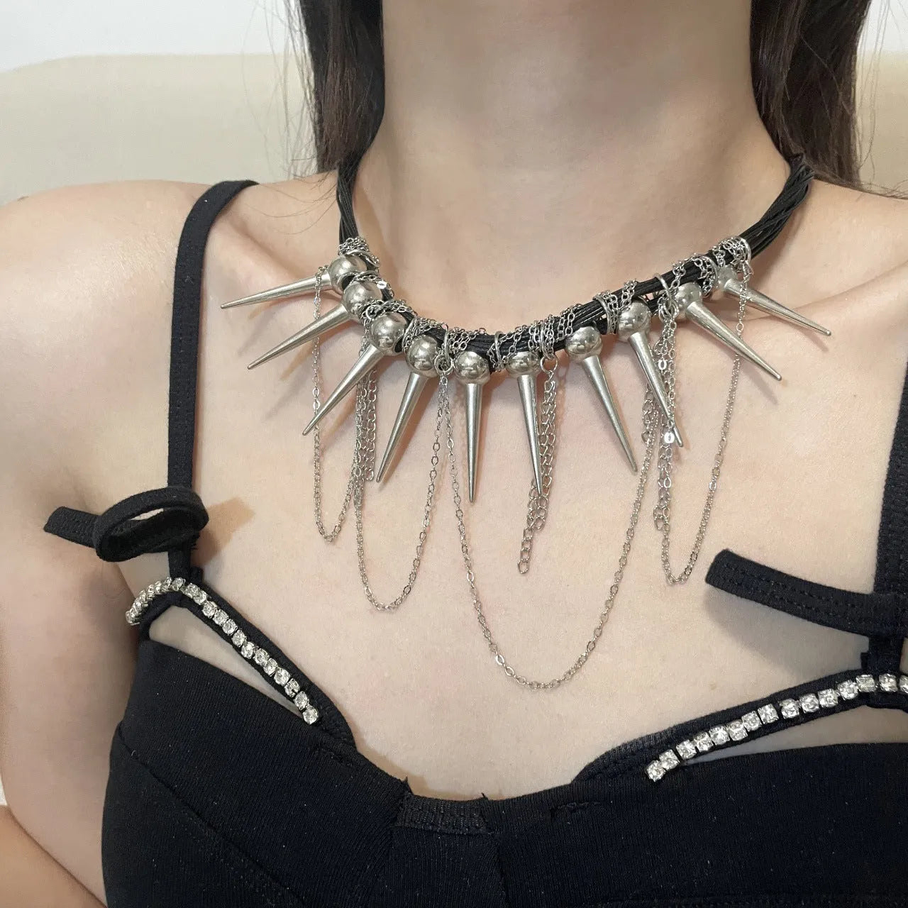 Women's leather necklace with winding rivet beads and a tassel in casual style.