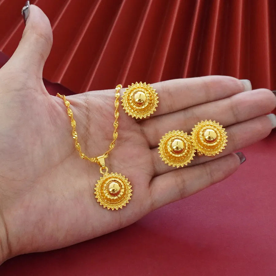 Gold-plated three-piece jewellery set with necklace, earrings, and ring in a floral design.