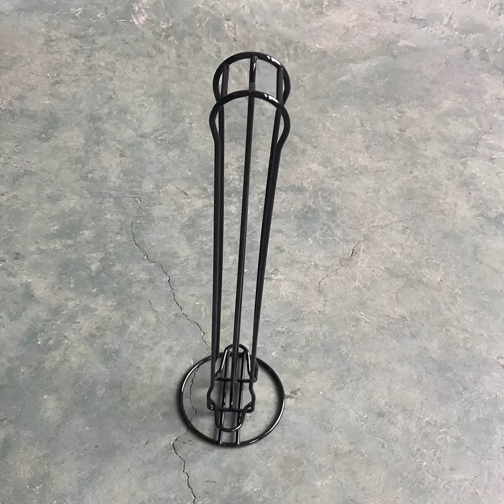 Black iron coffee capsule storage rack holding pods on display shelves.