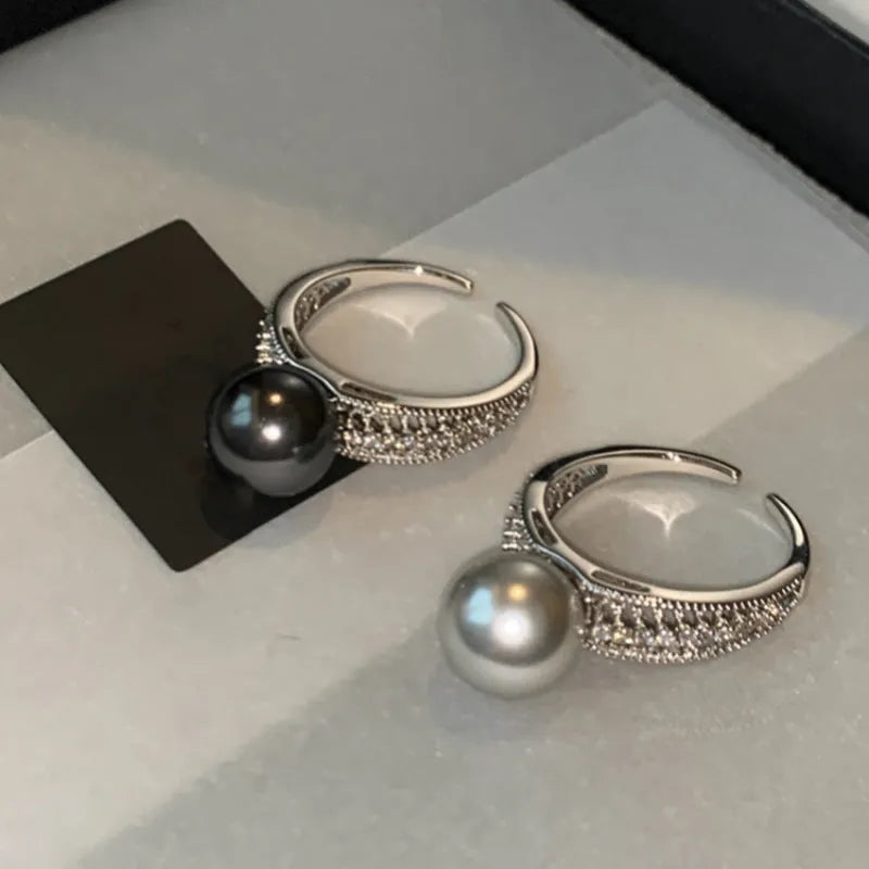 Geometric open copper ring with black pearl finish on a model's finger, showing adjustable design.