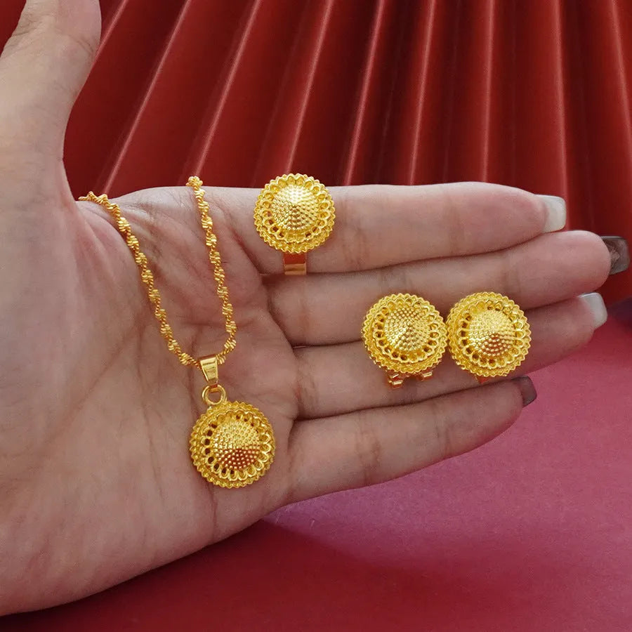 Gold-plated three-piece jewellery set with necklace, earrings, and ring in a floral design.