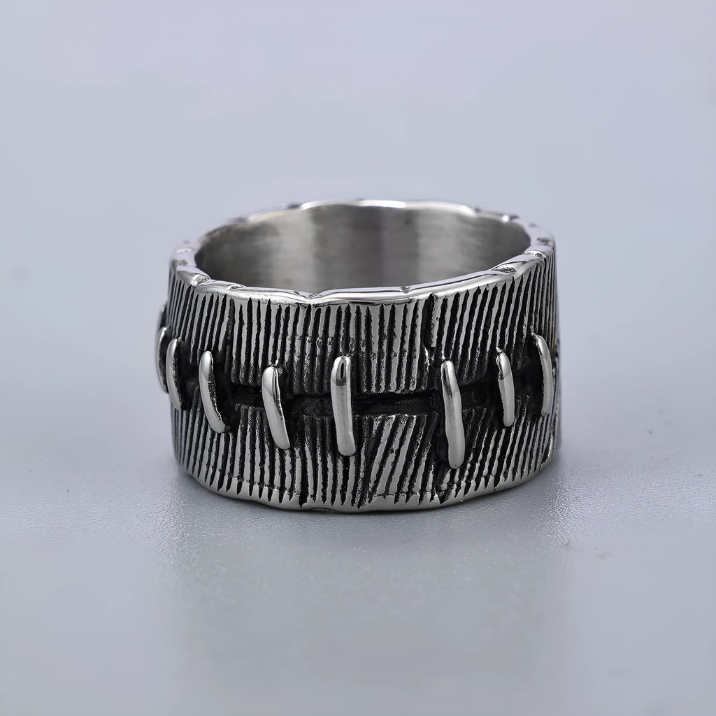 Geometric dark punk titanium steel double ring in retro colour, showing stitched design on a hand.