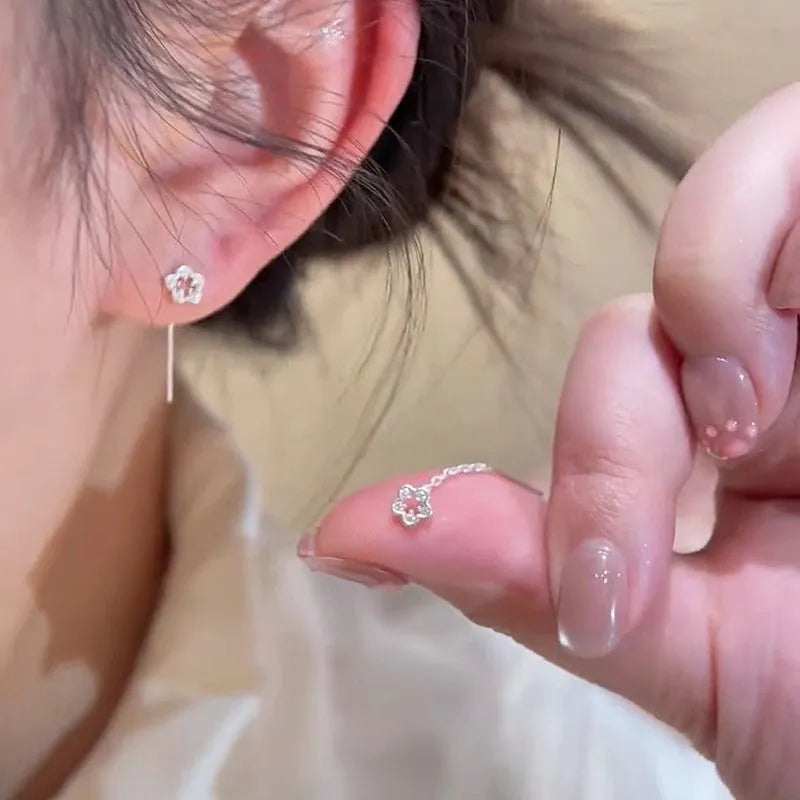 Pair of silver colour hollow flower stud earrings with detailed petal elements and needle posts