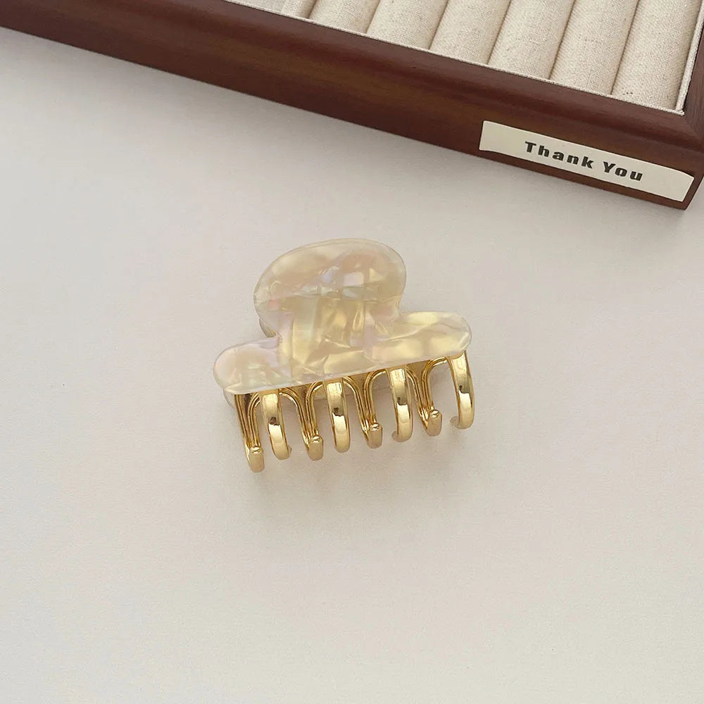 A medium-size retro-style hair barrette with a metal grip, in an alloy acrylic construction.
