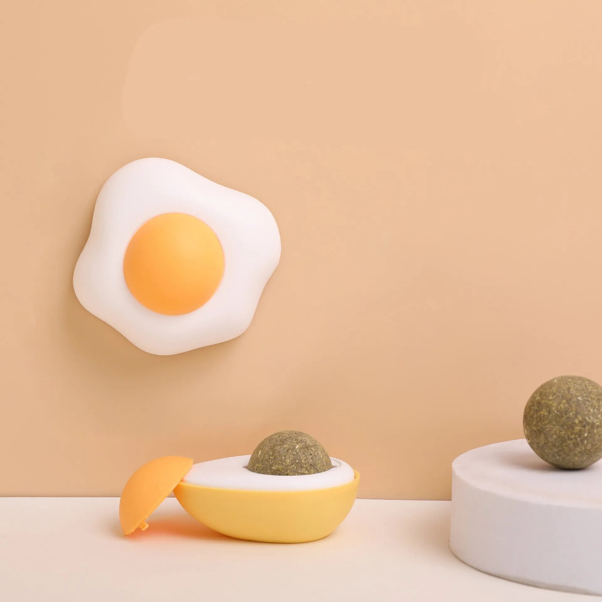 Catnip ball toy in fried egg and poached egg shapes with adhesive backing for wall mounting